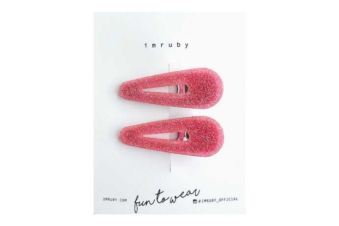 Hi! I'm LEIA, a set of two pink glitter teardrop clips.

Sparkly, sweet, and always in the mood to shine. I hold your hair in place with just the right grip — no pulling, no slipping. Lightweight and shaped to stand out, even when you're keeping it casual. Clip me in and carry on.