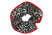 Load image into Gallery viewer, Hi! I&#39;m LOULOU, a leopard scrunchie with a red trim.

Tame your mane in style. I’m fierce, fun, and seriously comfy. With a wild leopard print and a pop of red, I add just the right edge to your everyday look.