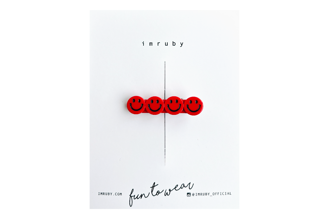 Red smiley face hair clip on a white card with 'imruby' branding.