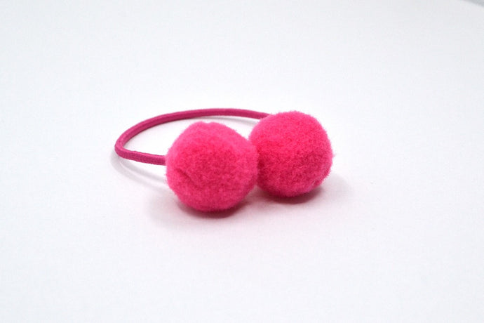 Hi! I'm BRUNA, a bright pink elastic hair ties set.  Be on trend with this set of pom hair ties! This 2 pack of hair ties comes in bright pink. 